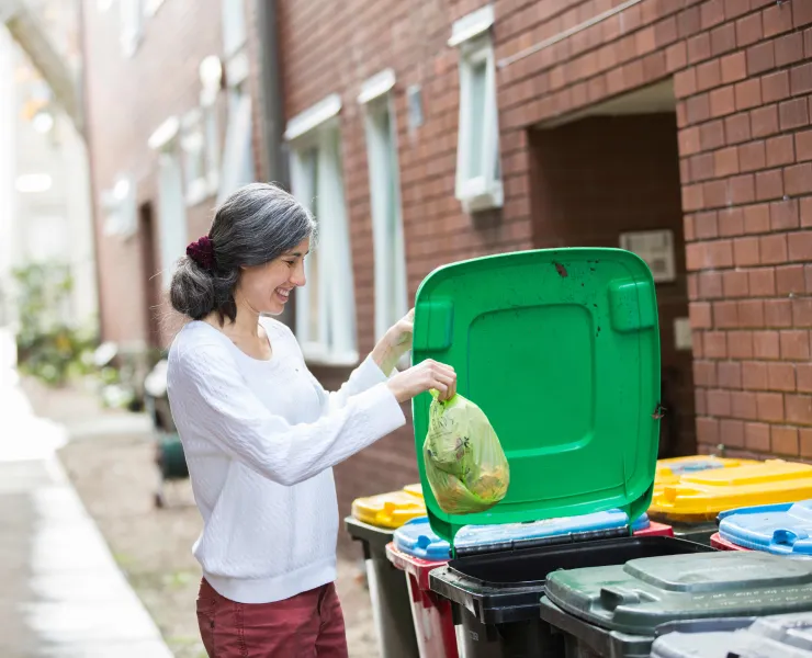 Female resident disposing of waste in bin